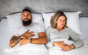 Frustrated couple laying in bed