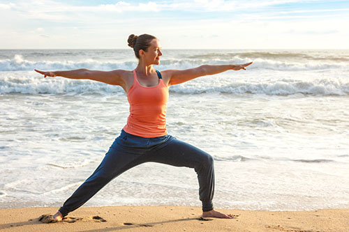 Woman doing yoga on the beach